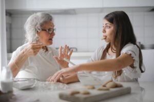 A grandma and a girl in a kitchen.