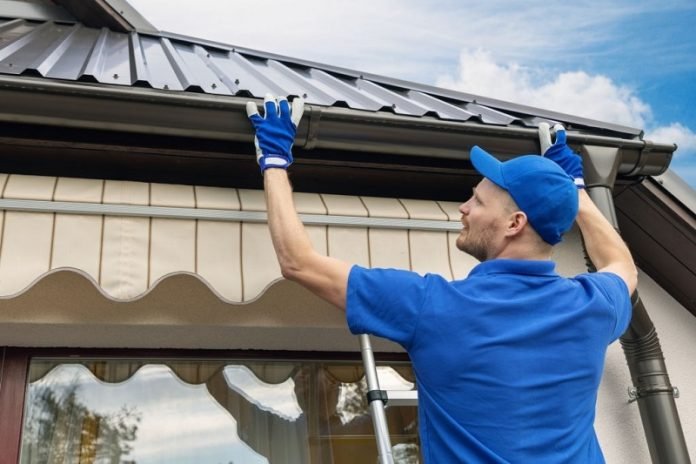 man installing house roof rain gutter system Select the Best Guards for Your Guttering System